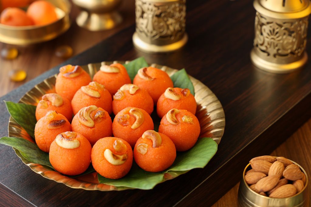 Laddoo decorated with cashews, served on a beautiful plate.