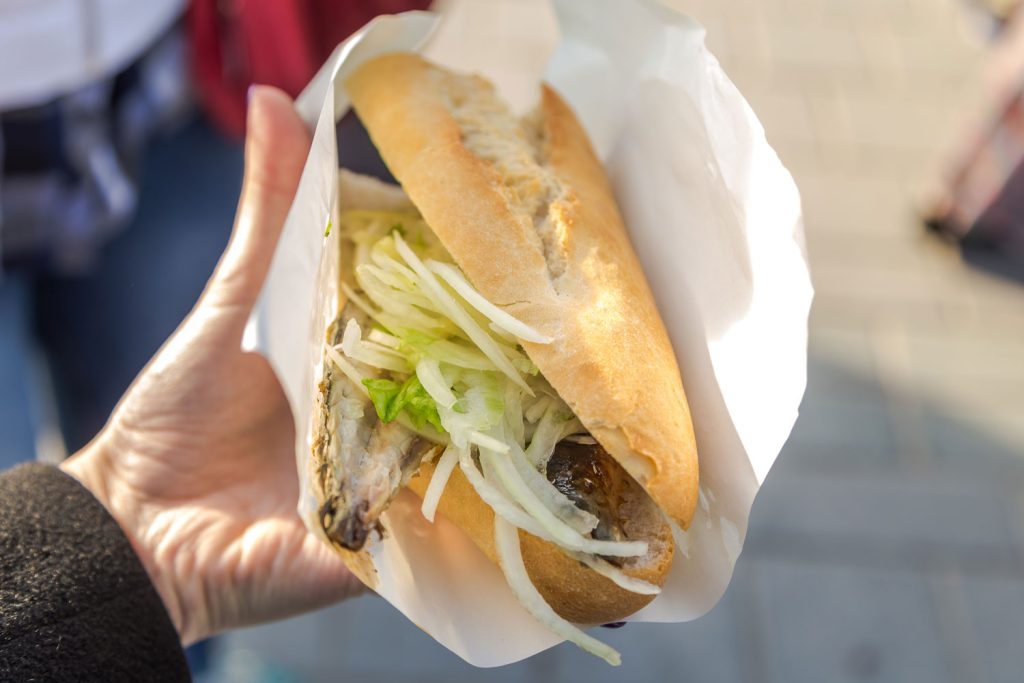 Holding a traditional fish sandwich.