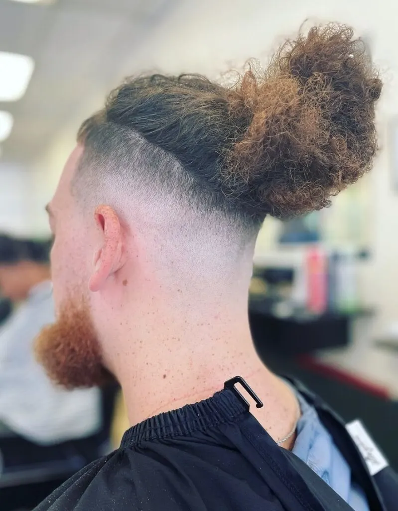 long curly topknot with bald fade