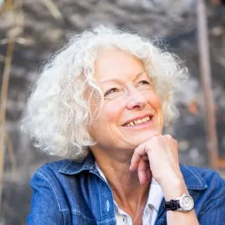 short curly hairstyle for women over 50 with oval faces